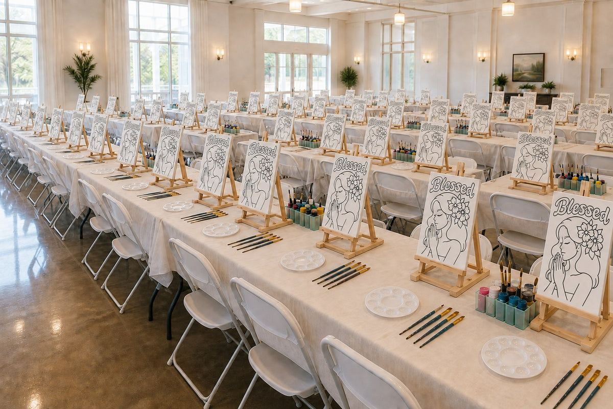 Long banquet tables set with pre-outlined canvases, easels and paint for a large paint party