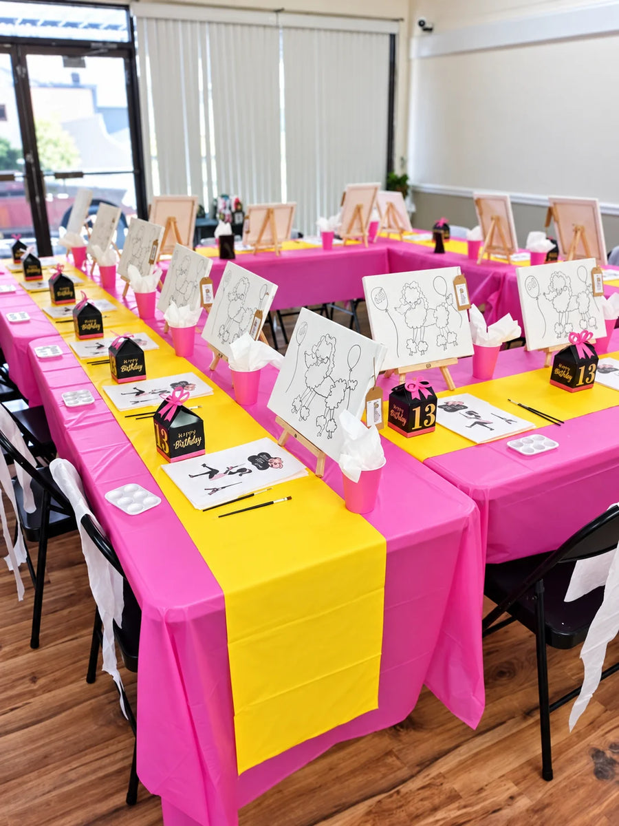 A birthday paint party table with pre-drawn canvases