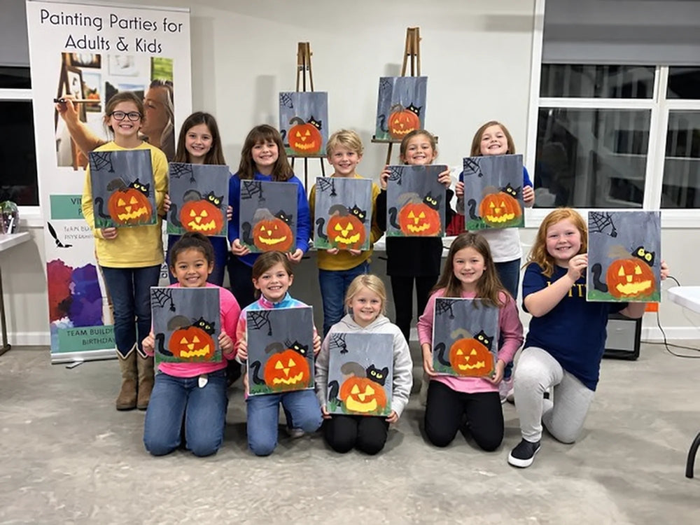 Children holding their Halloween pumpkin canvases